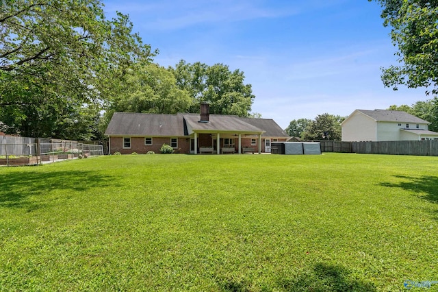 24961 Capshaw Rd, Athens, AL 35613 - rear view of property with a fenced backyard, a chimney, and brick siding