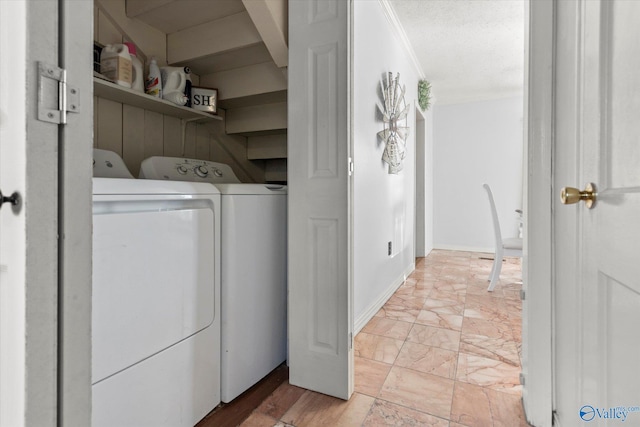 laundry room with laundry area, crown molding, baseboards, and separate washer and dryer