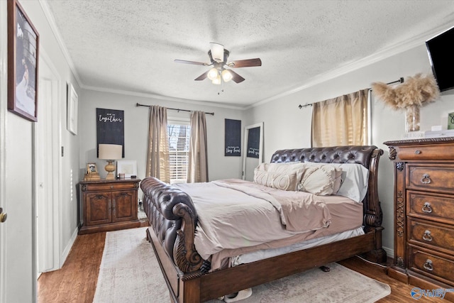 bedroom with crown molding, a ceiling fan, wood finished floors, a textured ceiling, and baseboards
