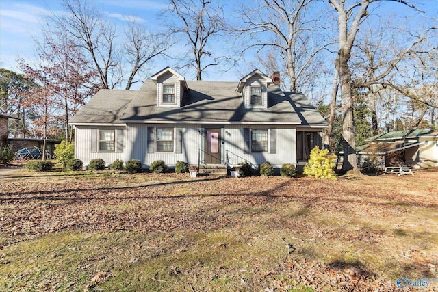 cape cod-style house with entry steps and a chimney