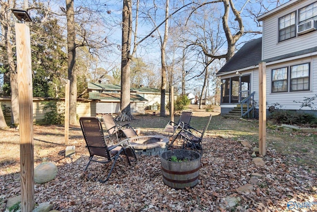view of yard featuring a sunroom and a fire pit