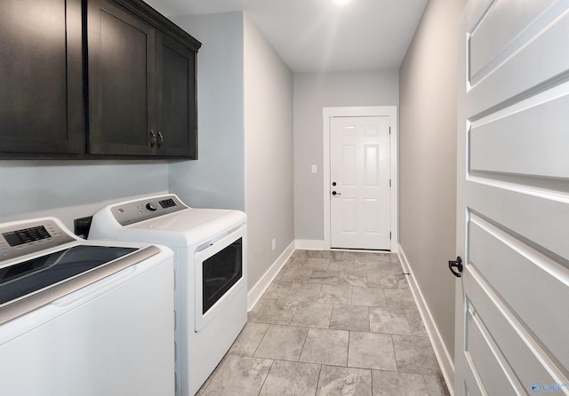 clothes washing area with cabinets and separate washer and dryer