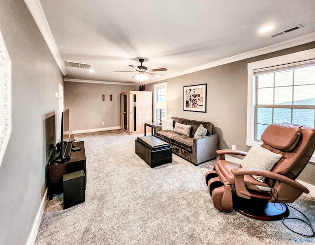 carpeted living room with crown molding and ceiling fan