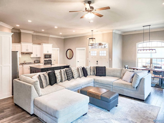 living room with sink, hardwood / wood-style flooring, crown molding, and ceiling fan