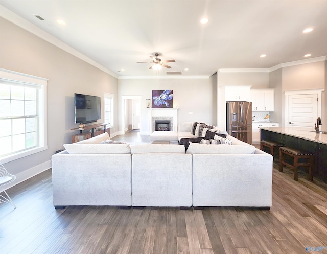 living room with ceiling fan, crown molding, and dark hardwood / wood-style floors