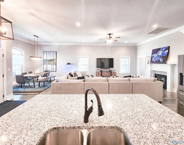 kitchen with a healthy amount of sunlight, light stone counters, and pendant lighting