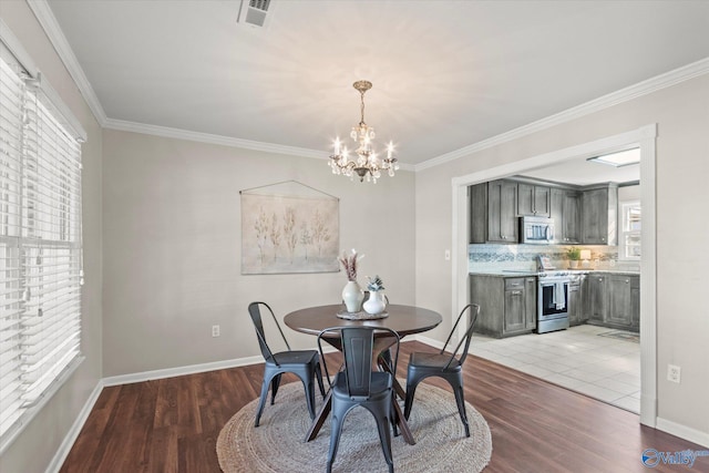 dining space with a notable chandelier, crown molding, and light hardwood / wood-style floors