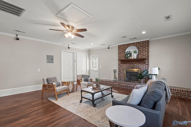 living room with crown molding, a brick fireplace, and dark hardwood / wood-style flooring