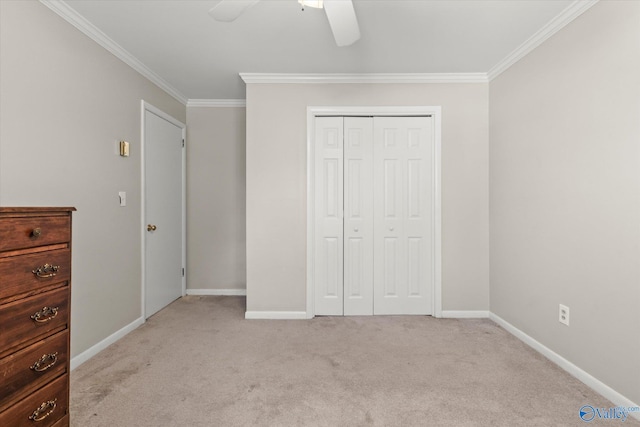 unfurnished bedroom with crown molding, light colored carpet, a closet, and ceiling fan