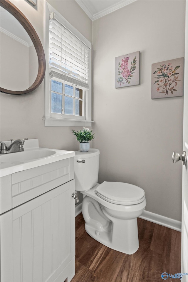 bathroom with ornamental molding, wood-type flooring, vanity, and toilet