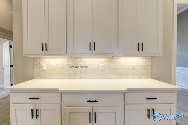 bar with white cabinetry, hardwood / wood-style flooring, and tasteful backsplash