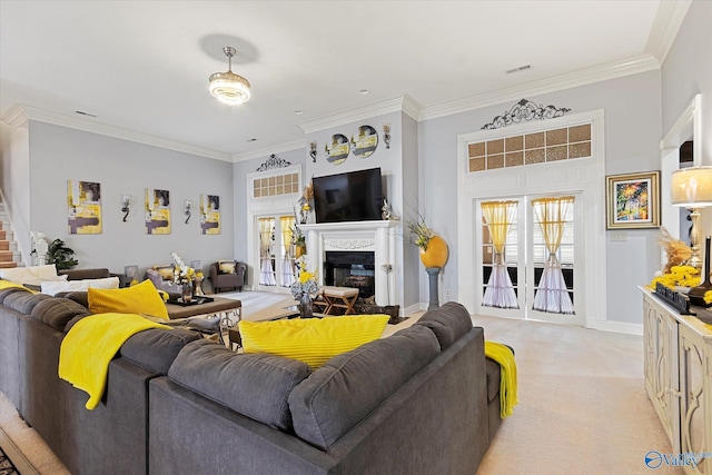 living room with ornamental molding, a glass covered fireplace, visible vents, and light colored carpet