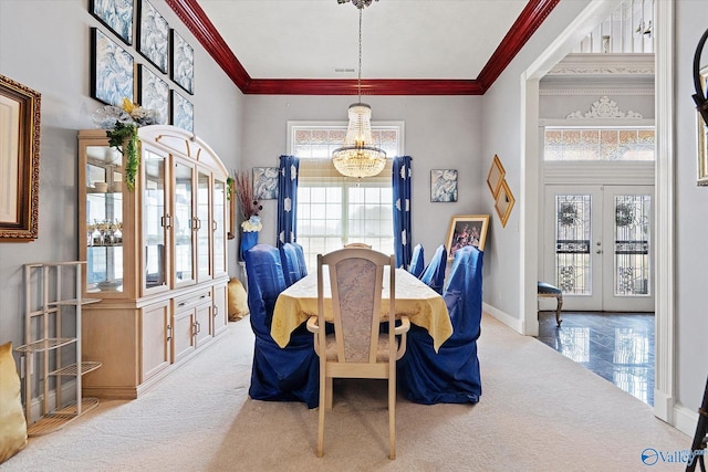 carpeted dining room with visible vents, baseboards, an inviting chandelier, crown molding, and french doors