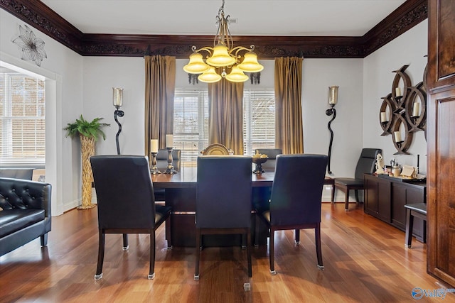 dining room with baseboards, crown molding, an inviting chandelier, and wood finished floors