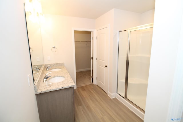 bathroom with hardwood / wood-style floors, vanity, and walk in shower