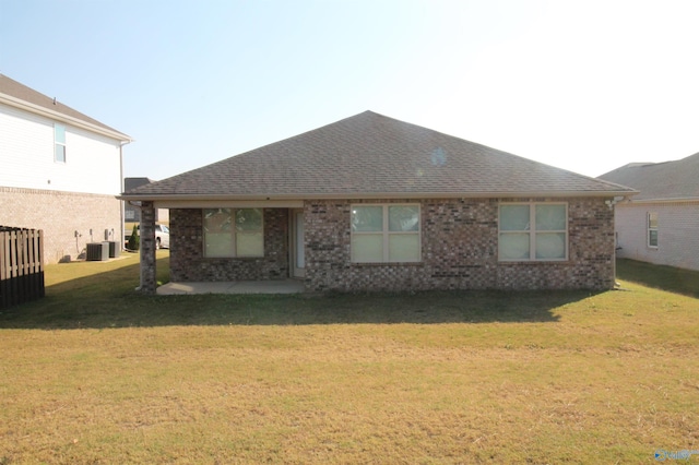 rear view of property with a yard and central AC unit