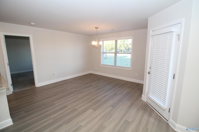 unfurnished room featuring hardwood / wood-style floors and a chandelier