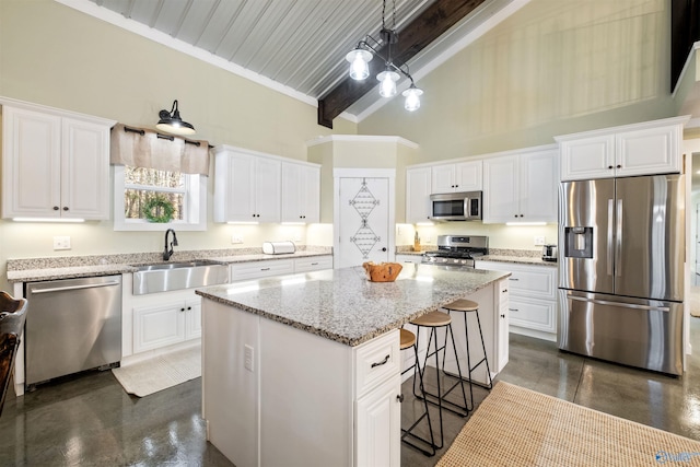 kitchen featuring beam ceiling, a center island, sink, stainless steel appliances, and pendant lighting