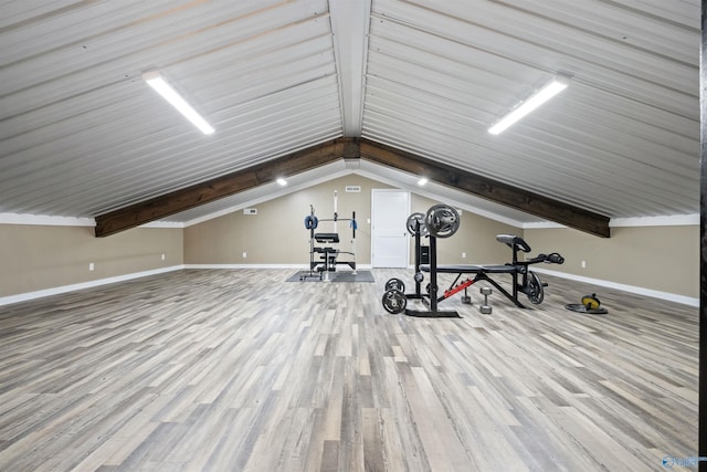 workout area featuring light hardwood / wood-style floors and lofted ceiling