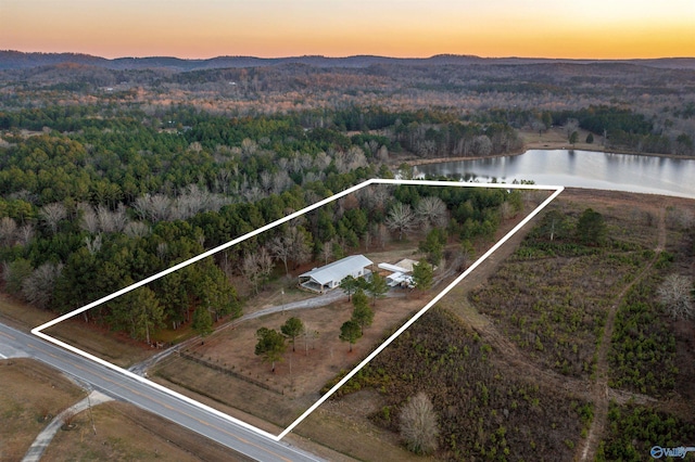 aerial view at dusk featuring a water and mountain view