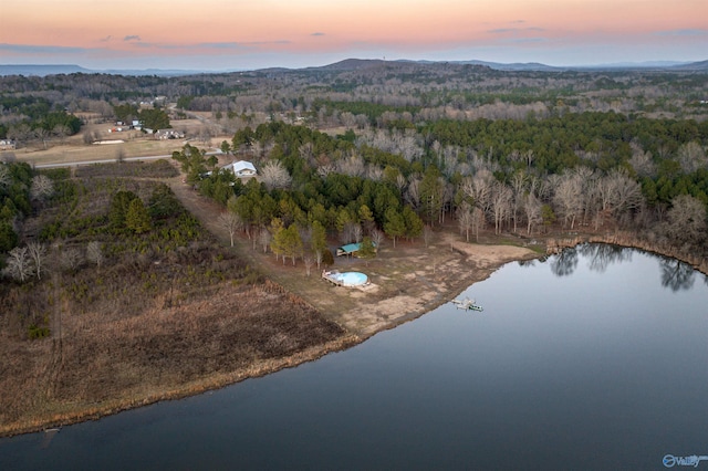 aerial view at dusk featuring a water view