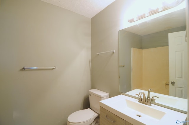 bathroom with vanity, a textured ceiling, and toilet