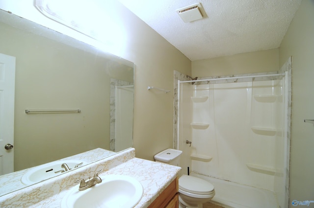 bathroom featuring toilet, vanity, and a textured ceiling