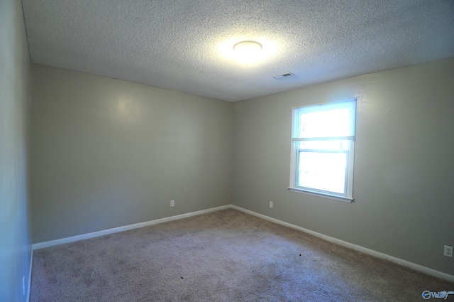 carpeted spare room with a textured ceiling