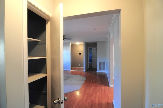 corridor featuring ornamental molding and dark hardwood / wood-style floors