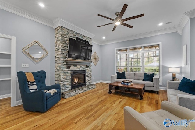 living room with a fireplace, ornamental molding, hardwood / wood-style floors, and ceiling fan