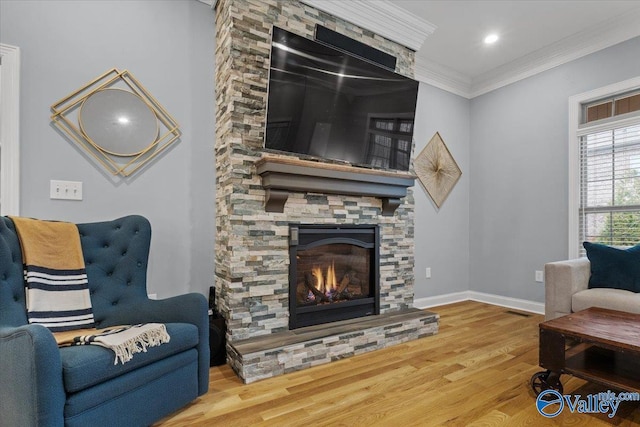 living room with a fireplace, hardwood / wood-style floors, and crown molding