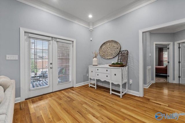 foyer entrance with light wood-type flooring, french doors, crown molding, and plenty of natural light