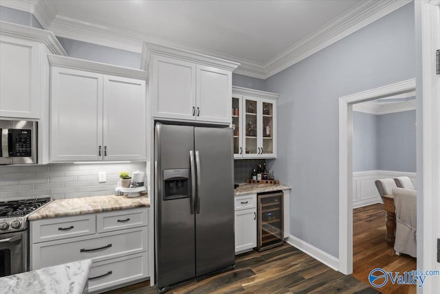 kitchen featuring stainless steel appliances, light stone countertops, white cabinets, beverage cooler, and ornamental molding