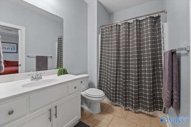 bathroom featuring curtained shower, tile patterned floors, toilet, and vanity