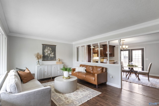 living area with crown molding, dark wood-style floors, a chandelier, and baseboards