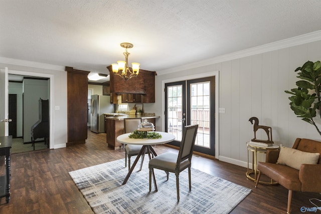 dining room with crown molding, an inviting chandelier, and dark wood-type flooring