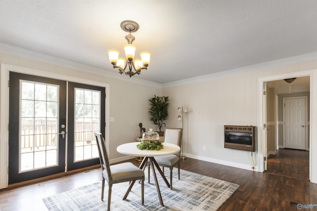 dining room with heating unit, an inviting chandelier, ornamental molding, french doors, and dark wood-type flooring