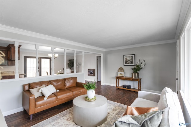 living room with baseboards, ornate columns, wood finished floors, and ornamental molding
