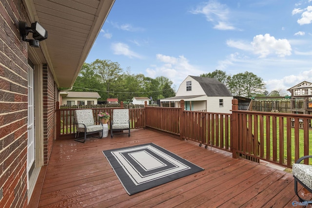 deck with an outbuilding, a shed, and fence