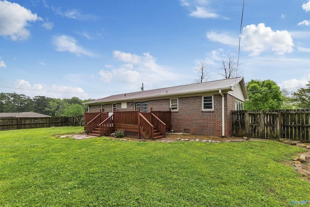 rear view of property featuring stairs, a wooden deck, metal roof, brick siding, and a fenced backyard