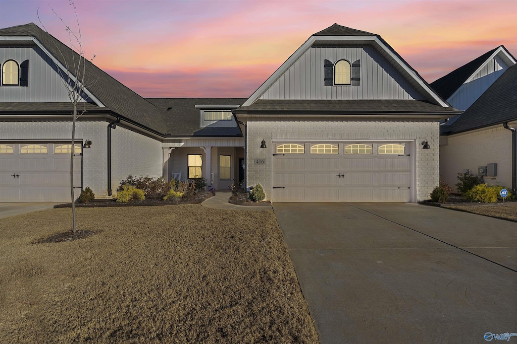 view of front of home with a garage and a yard