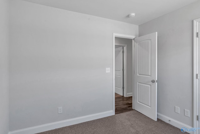 carpeted spare room featuring baseboards