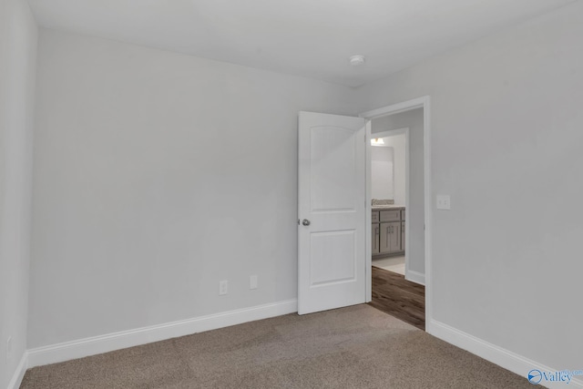 unfurnished room featuring carpet and baseboards