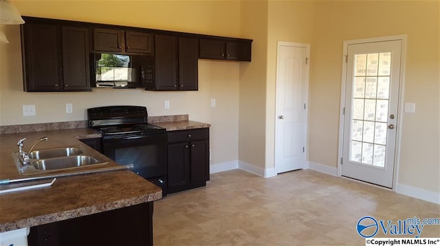 kitchen featuring black appliances, baseboards, dark brown cabinets, and a sink