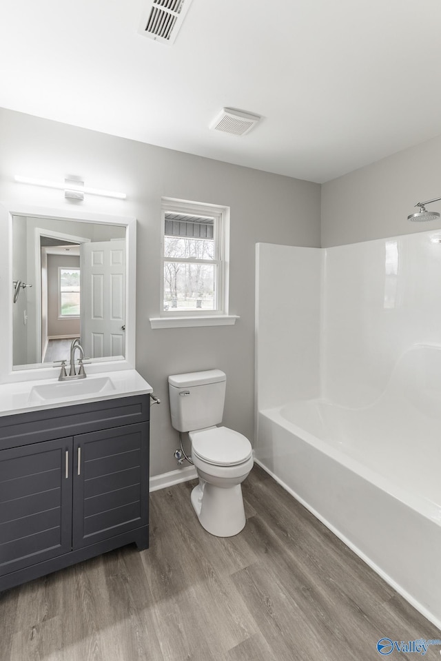 full bathroom with hardwood / wood-style floors, vanity, toilet, and a wealth of natural light