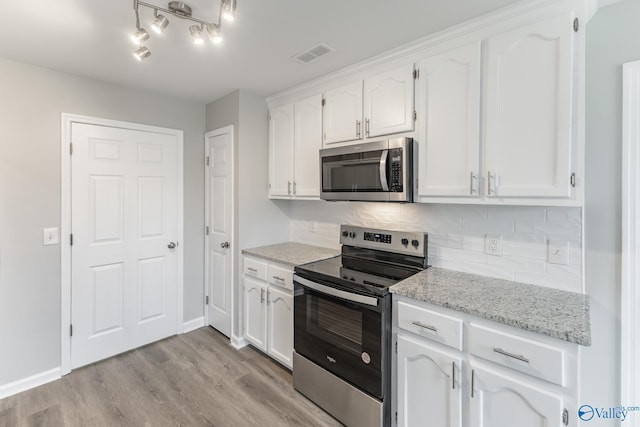 kitchen featuring white cabinetry, stainless steel appliances, and light stone counters