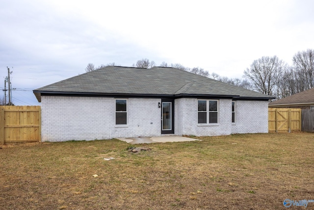 rear view of property with a lawn and a patio