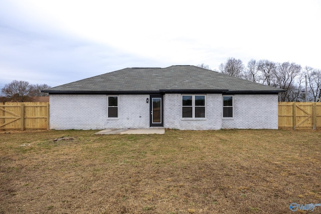 back of property with a lawn and a patio area