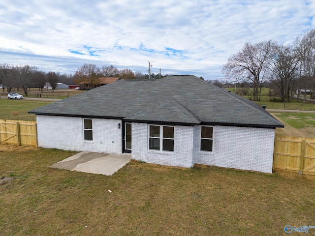 back of house with a lawn and a patio