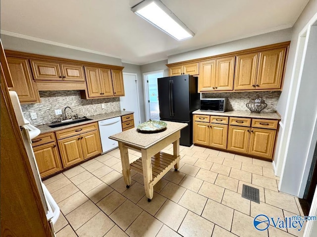 kitchen with black refrigerator, sink, backsplash, light tile patterned floors, and white dishwasher